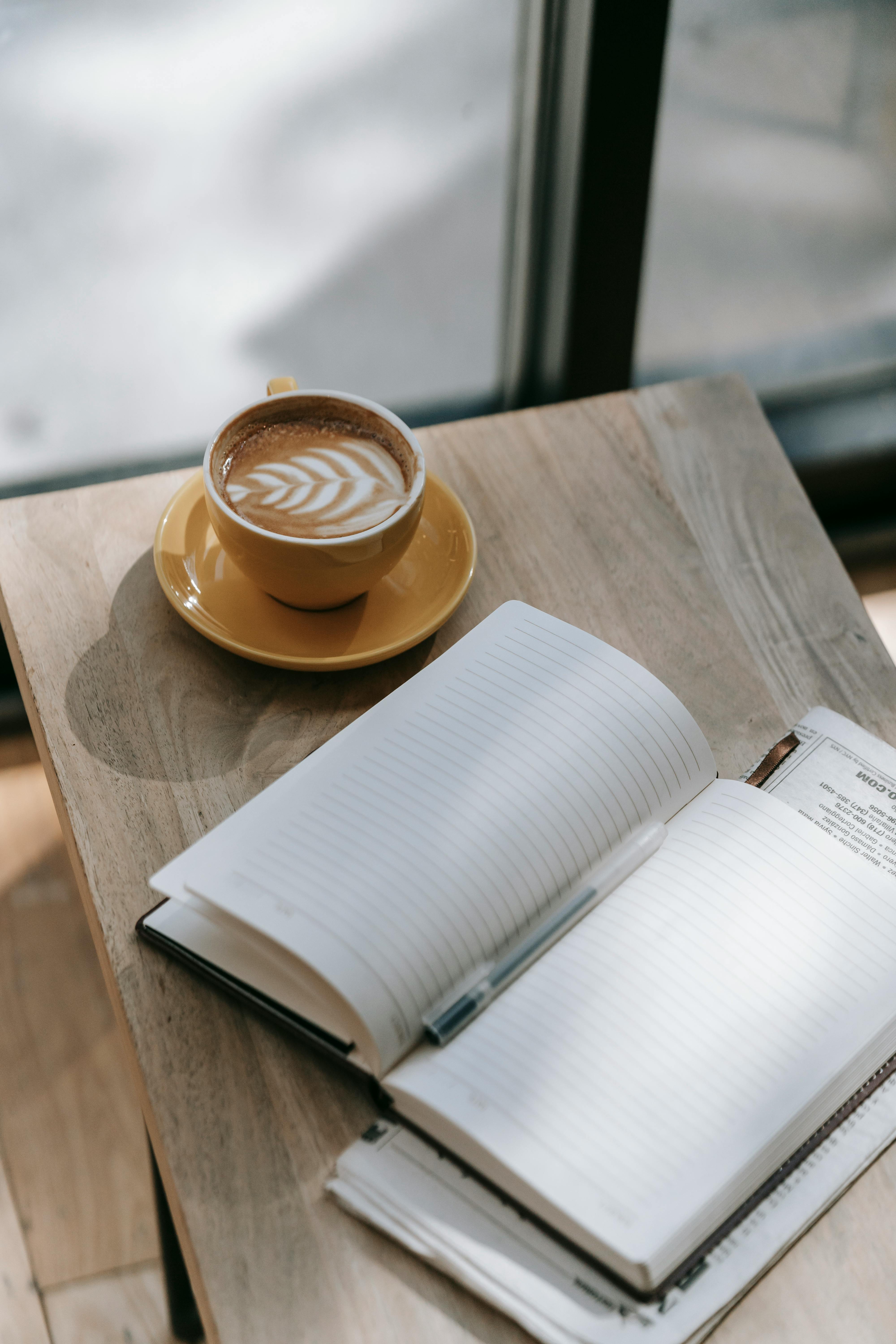 Coffee and notebook on a wooden desk
